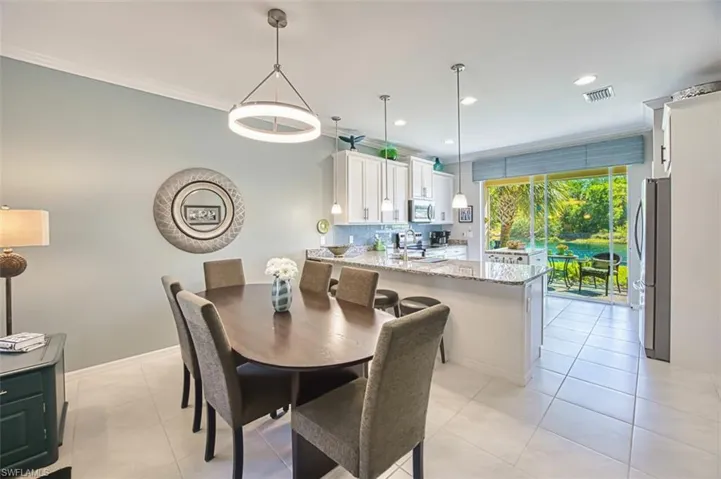Dining room with accent paint, Crown molding, recessed lighting, and light tile patterned flooring