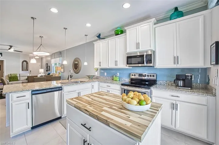 Kitchen stainless steel appliances, island with butcherblock top for extra work space and storage