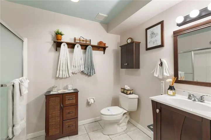 Bathroom with light tile patterned flooring, a stall shower, and vanity