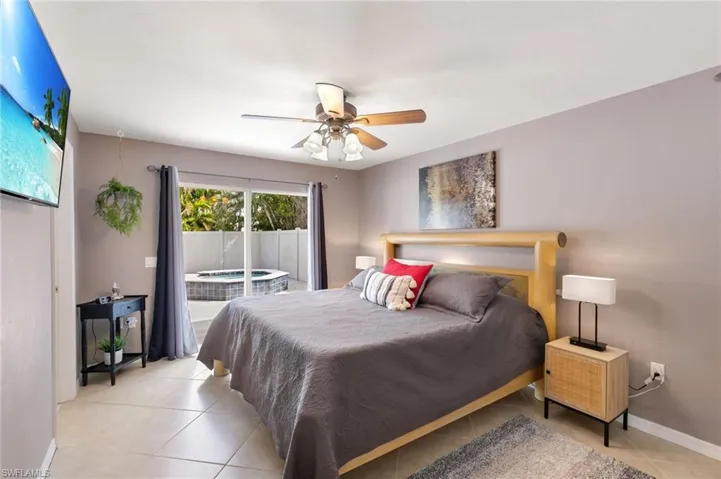 Bedroom featuring access to exterior, a ceiling fan, and light tile patterned floors