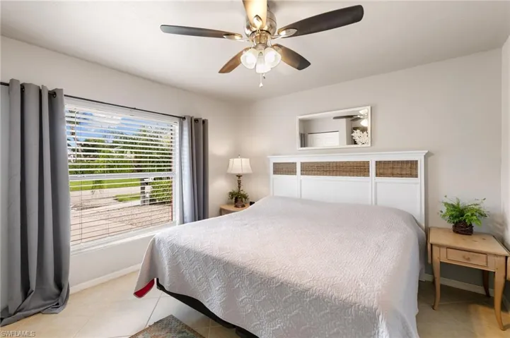 Bedroom with light tile patterned floors and ceiling fan