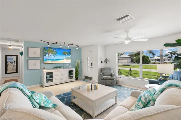 Living area with a ceiling fan and carpet