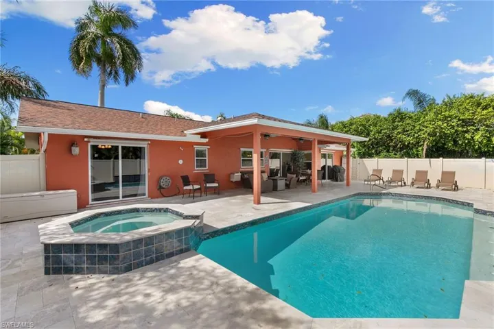 View of pool with a patio area, a fenced backyard, and a pool with connected hot tub