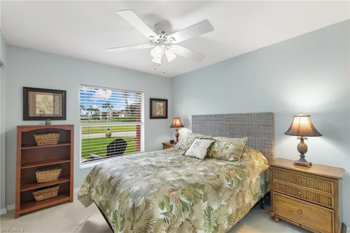 Bedroom with light tile patterned floors and a ceiling fan