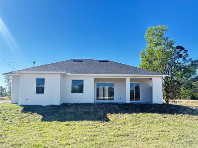 Rear view of property with a yard