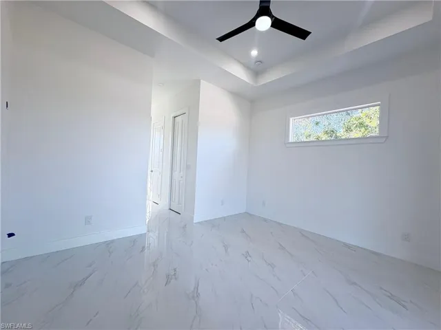 Empty room with a tray ceiling and ceiling fan