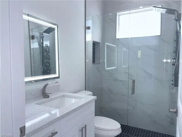 Bathroom featuring vanity, toilet, and walk in shower