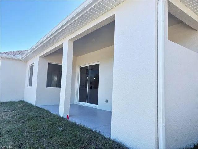 View of side of home featuring a yard and a patio