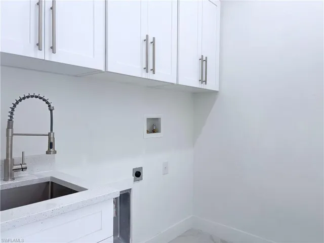 Washroom with electric dryer hookup, sink, cabinets, and washer hookup