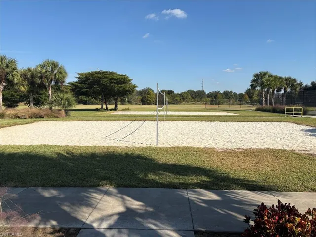 View of community with volleyball court and a lawn