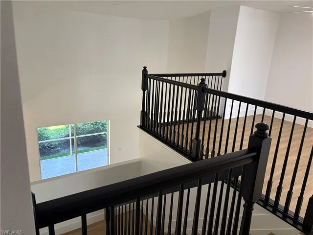 Staircase with wood finished floors and baseboards