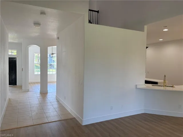 Unfurnished dining area featuring light wood-style flooring and arched walkways