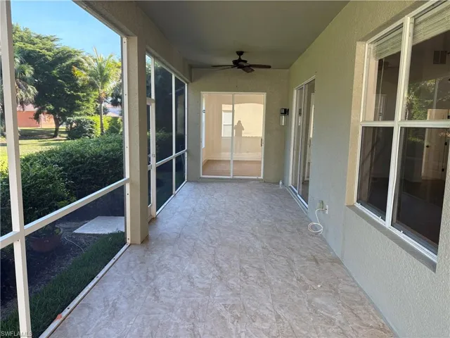 Unfurnished sunroom featuring a ceiling fan