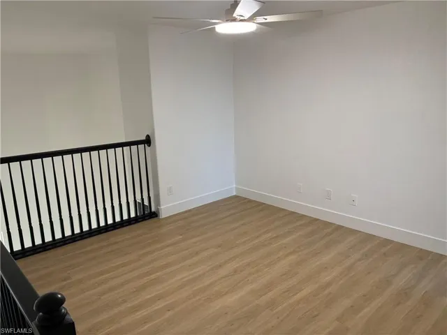 Empty room with light wood finished floors and a ceiling fan