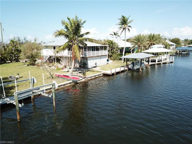 View of dock featuring a lawn, a water view, and boat lift