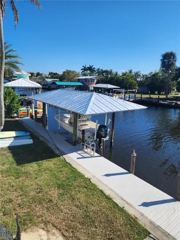 Dock with a yard, boat lift, and a water view