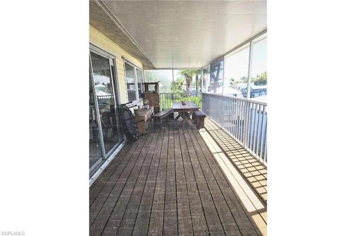 Wooden terrace featuring a sunroom