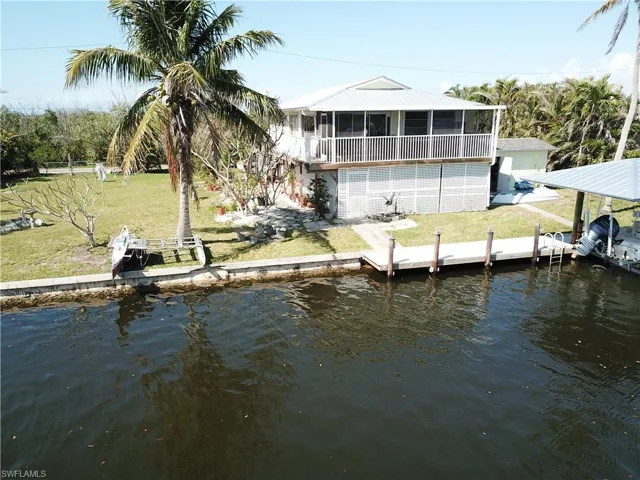 Dock area with a water view and a yard