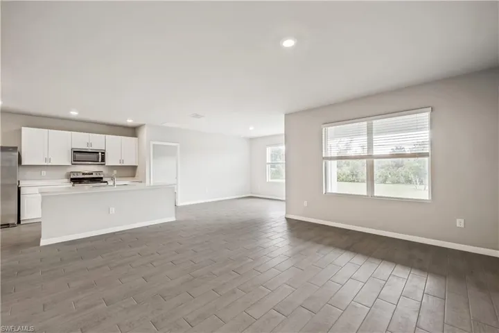 Unfurnished living room featuring sink and wood-type flooring