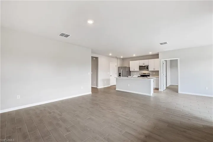 Unfurnished living room featuring light hardwood / wood-style floors and sink