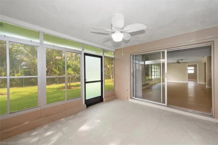 Screened enclosure featuring a ceiling fan, light-toned flooring, and direct access to the exterior yard