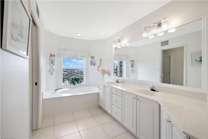 Bathroom featuring tile patterned floors, plus walk in shower, and vanity