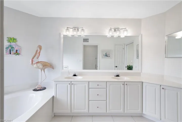 Bathroom with a washtub, vanity, and tile patterned floors