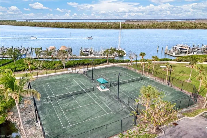 Birds eye view of tennis courts with a water view