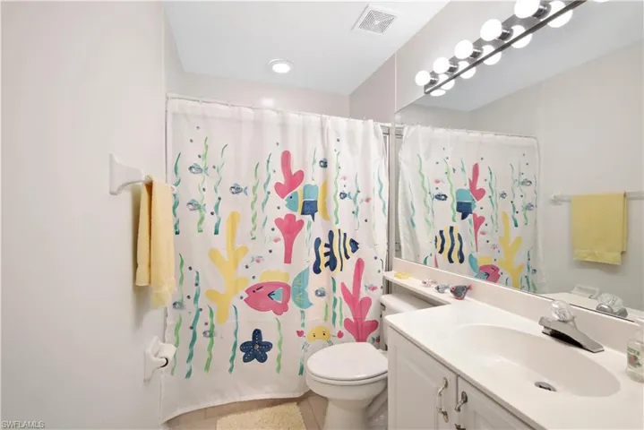 Bathroom with tile patterned flooring, vanity, toilet, and walk in shower