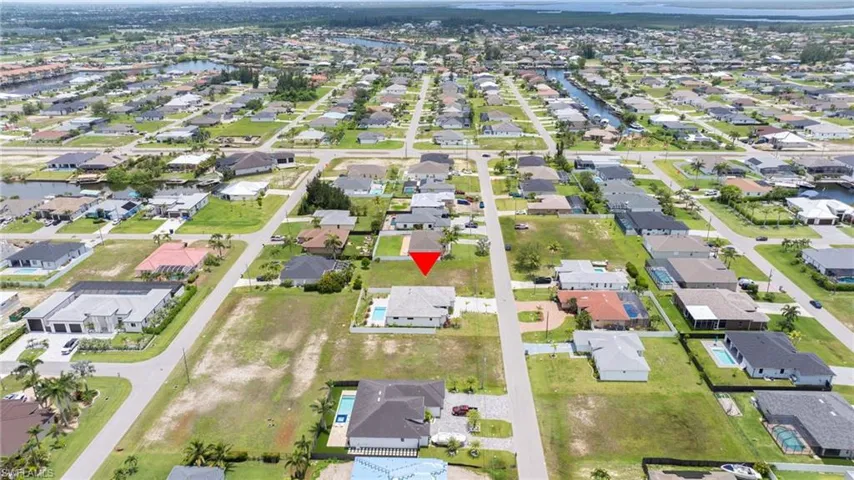 Aerial view of property and surrounding area with nearby suburban area and a large body of water