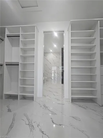 Walk in closet with marble finish floor