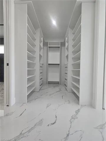 Walk in closet with marble finish floor