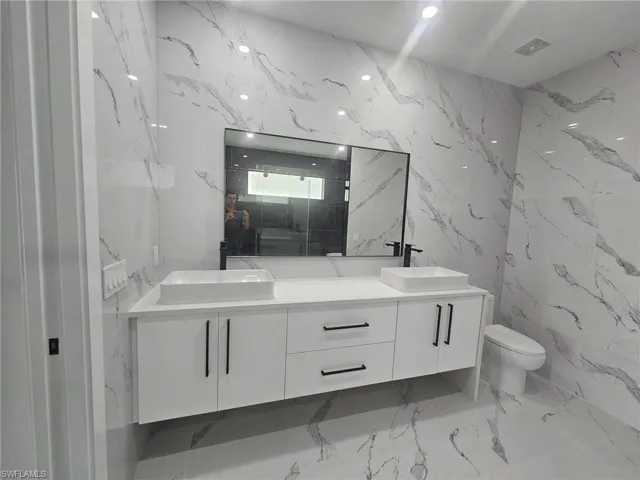 Full bath with stone wall and a sink