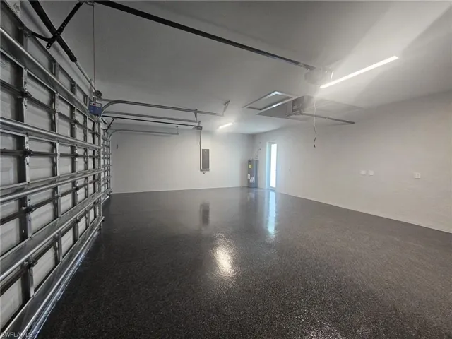 Garage featuring electric panel and electric water heater