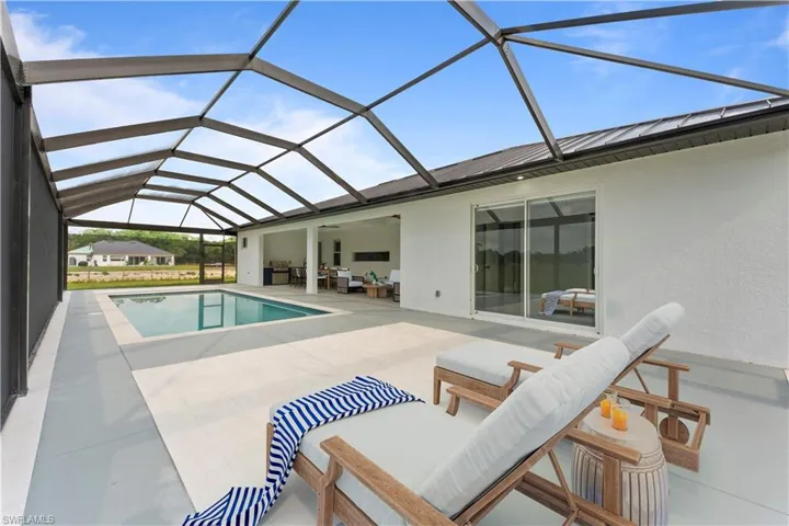 Outdoor pool featuring a lanai, outdoor lounge area, and a patio
