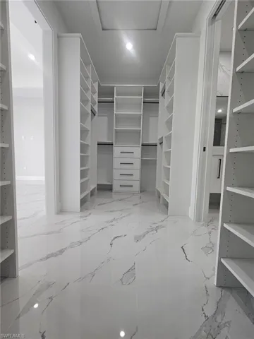 Spacious closet featuring attic access and marble finish floor