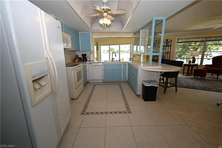 Kitchen featuring light blue cabinetry, tile flooring with decorative inlay, and a built-in breakfast bar