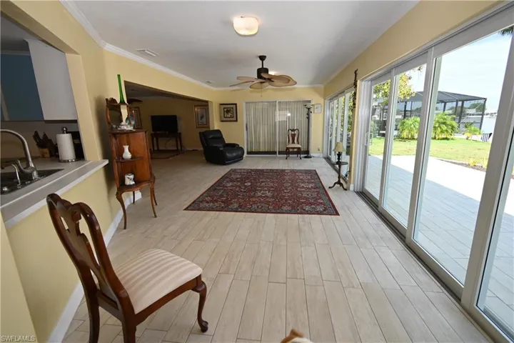 Spacious living area featuring light wood-finish flooring and a ceiling fan