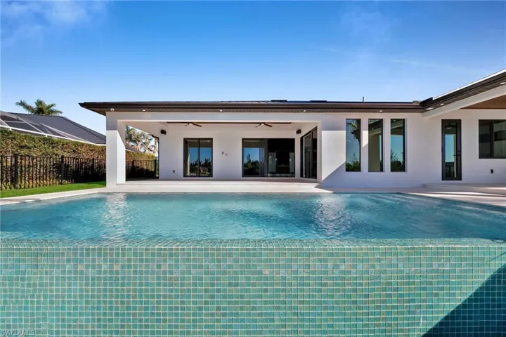View of swimming pool with ceiling fan and a patio area
