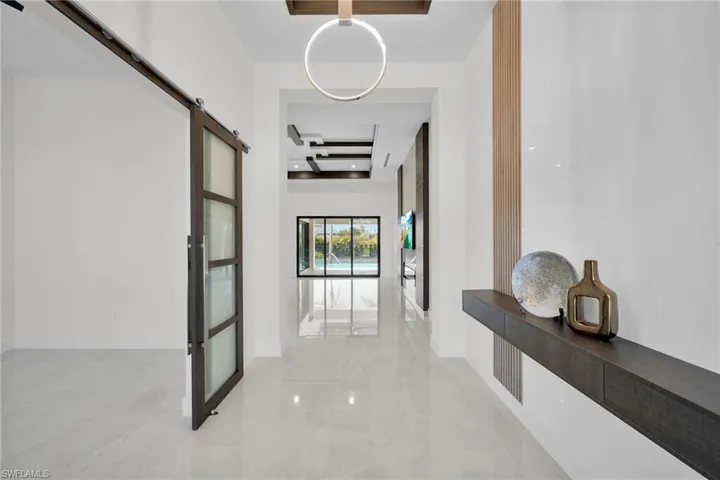 Hallway featuring beam ceiling and a barn door