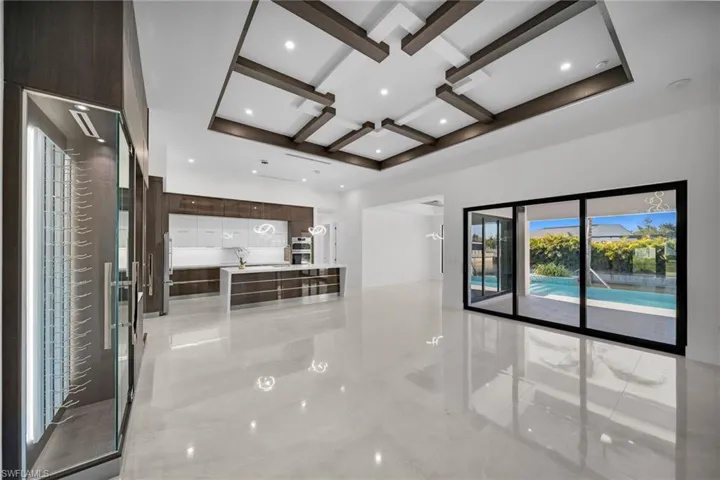 Unfurnished living room with beam ceiling and coffered ceiling