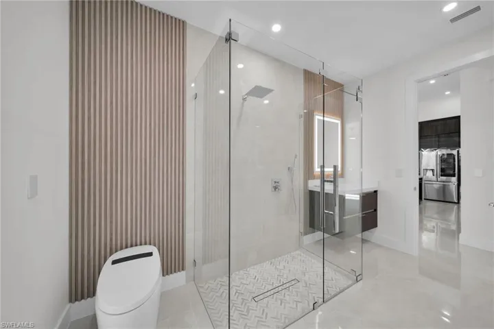 Bathroom with toilet, vanity, concrete flooring, and walk in shower