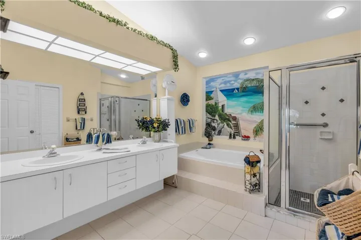 Bathroom with tile patterned flooring, shower with separate bathtub, and vanity