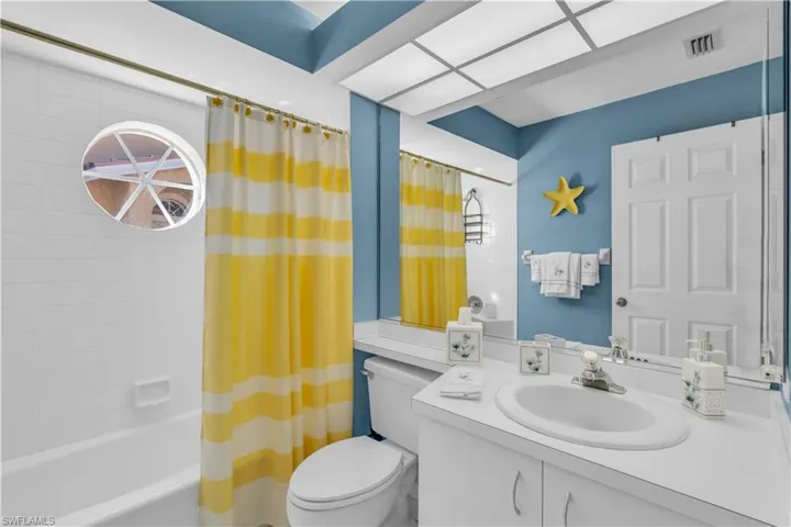 Full bathroom featuring vanity, shower / bath combo, and toilet
