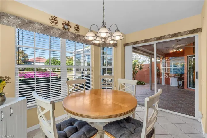 Dining space with light tile patterned floors and a chandelier