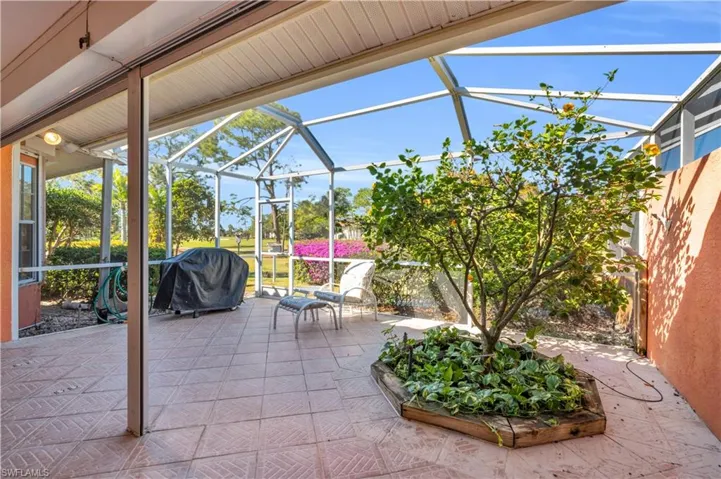 View of patio featuring area for grilling and glass enclosure