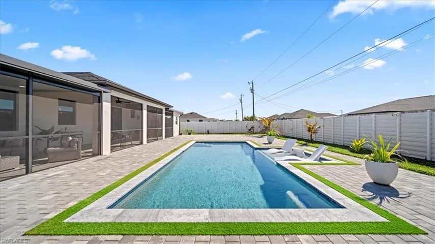 View of swimming pool featuring patio surround, a fenced backyard, and a sunroom