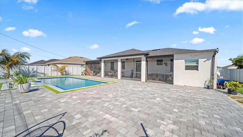 View of pool featuring a sunroom, a fenced backyard, and patio surround