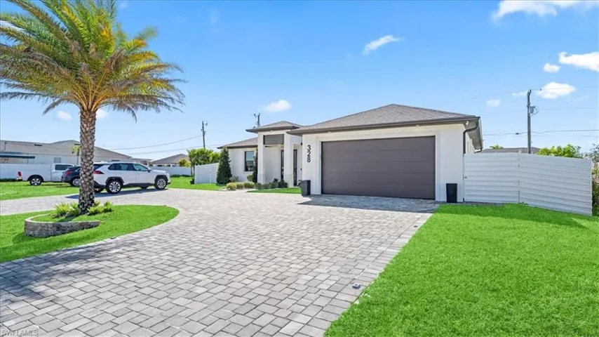 Prairie-style home with curved driveway, stucco siding, and a garage
