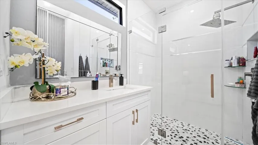 Full bathroom with vanity and a shower stall